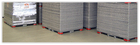 Cleaned reusable layer pads stacked on pallets, ready to return to the packaging pool